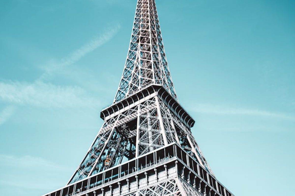 Stunning low angle view of the Eiffel Tower against a bright blue sky in Paris.