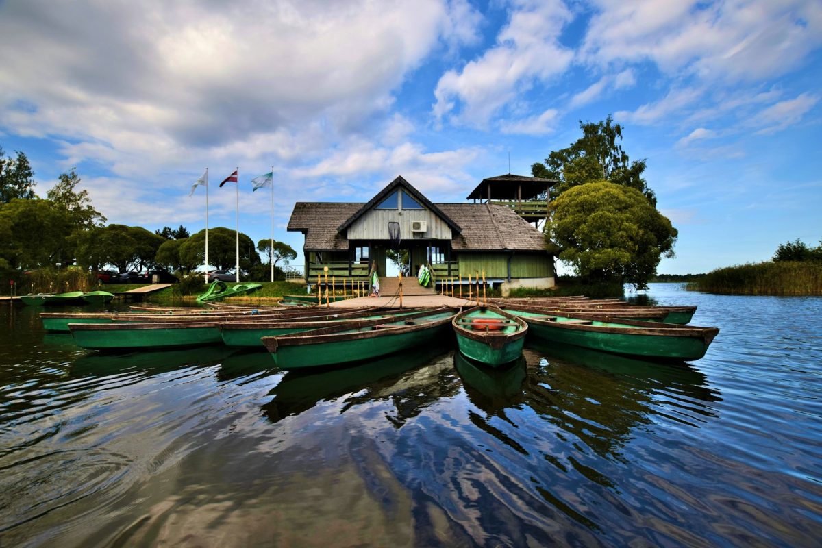 canoes docked in front of white and green house
