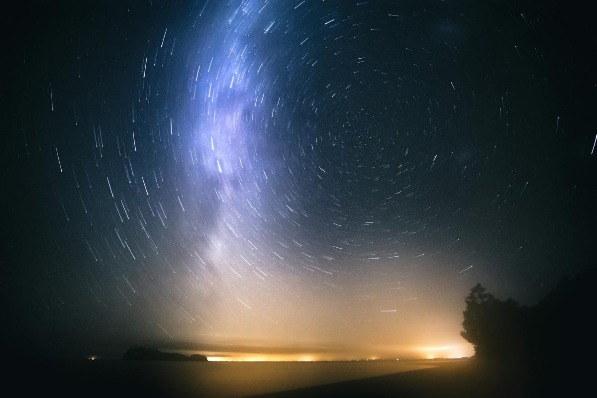 Beautiful long exposure of star trails over the New Zealand coast at night.