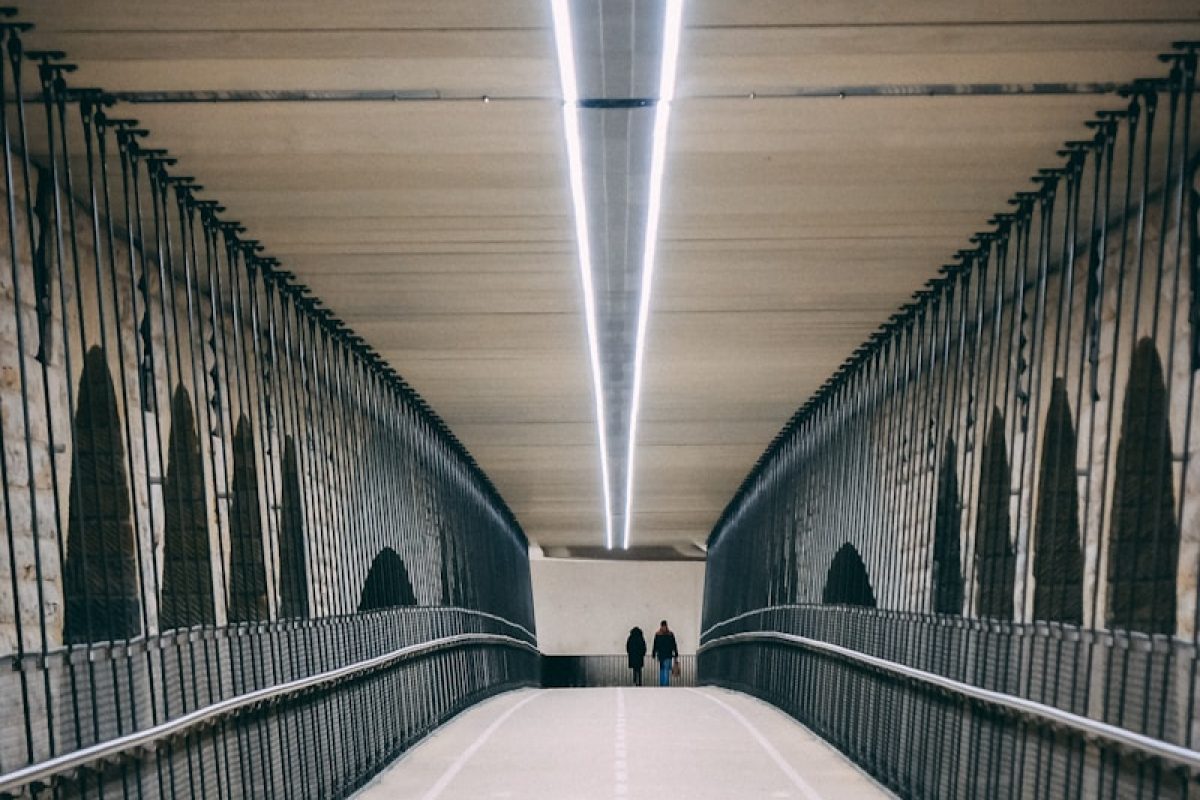 two person walking on bridge