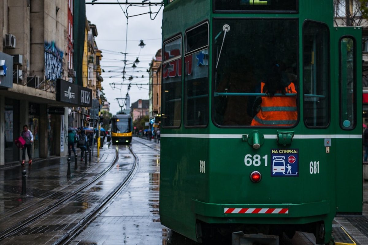 green tram on the street during daytime
