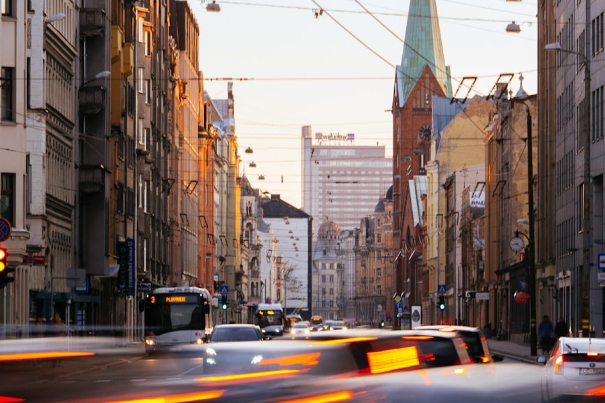 cars on road between high rise buildings during daytime