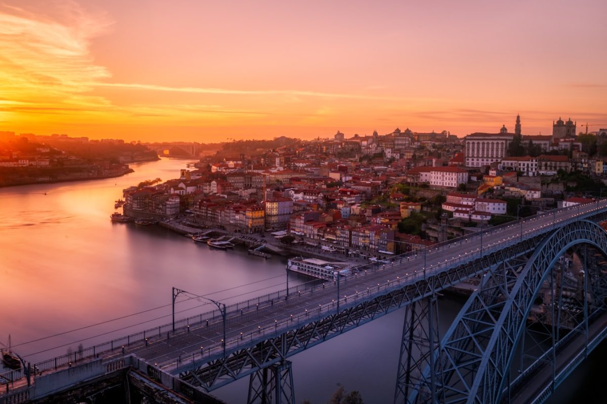 gray bridge near building at sunset